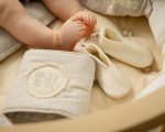 бебешки крачета до меки бебешки обувки от мериносова вълна върху уютна текстилна повърхност